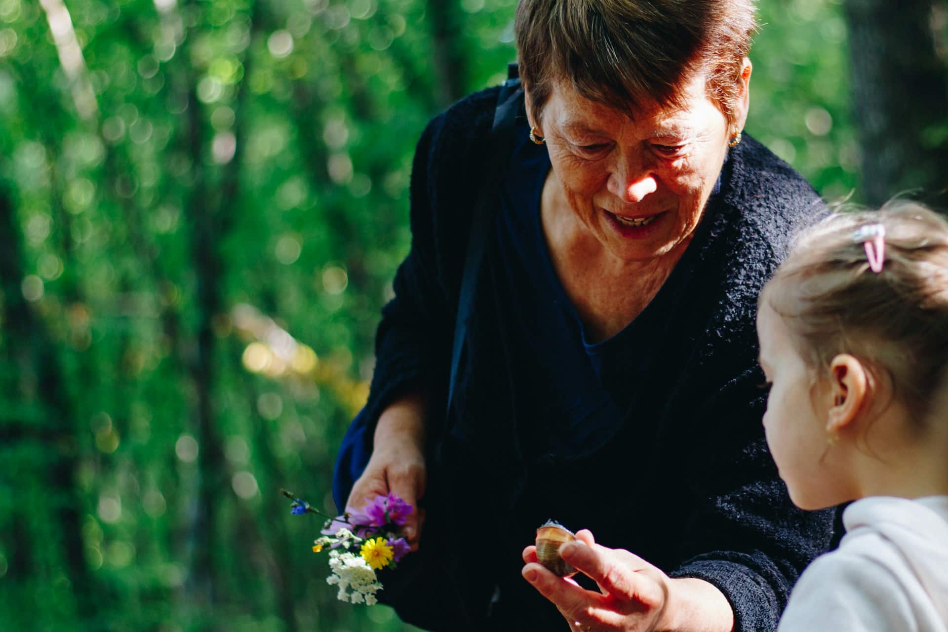 A grandma and granddaughter looking at flowers