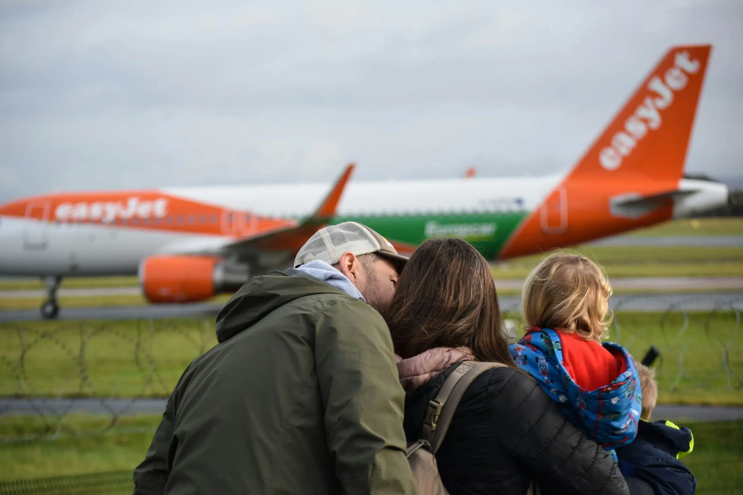 A family with young children looking at an airplane