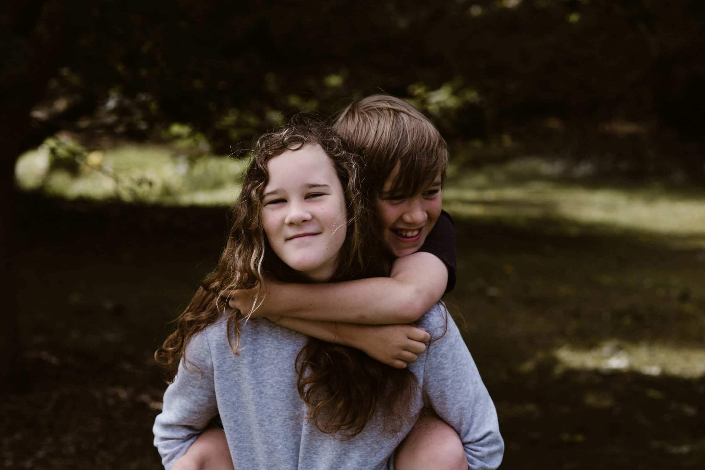 An older child holding their younger sibling