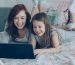 A mother and daughter using a laptop together
