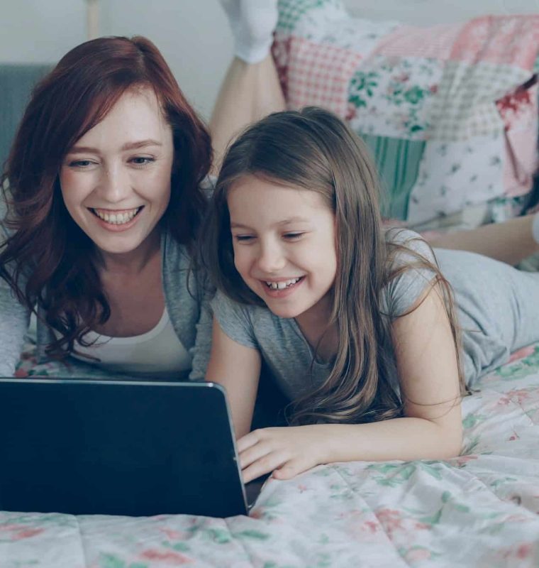 A mother and daughter using a laptop together